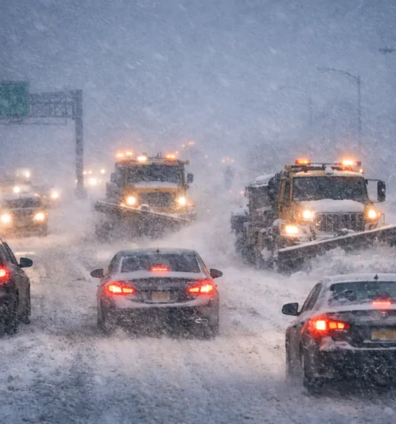 New Jersey Blizzard Warning: Vehicles and snowplows navigate a heavily snow-covered highway during a statewide blizzard warning.